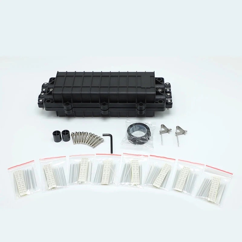 A horizontal inline fiber optic splice closure kit showing the elongated black housing alongside its mechanical clamp hardware, mounting screws, and splice protector sleeves
