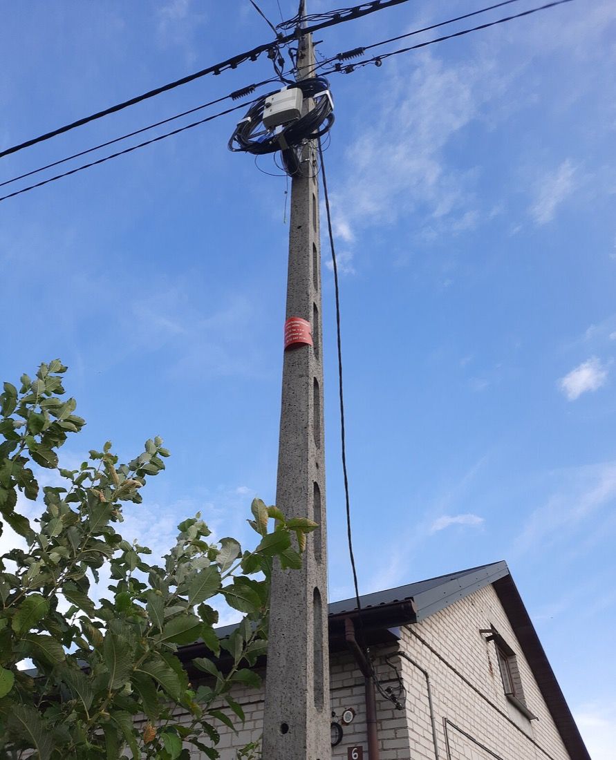 Aerial ADSS fiber optic cable on a utility pole with an FTTH closure and a coiled slack loop
